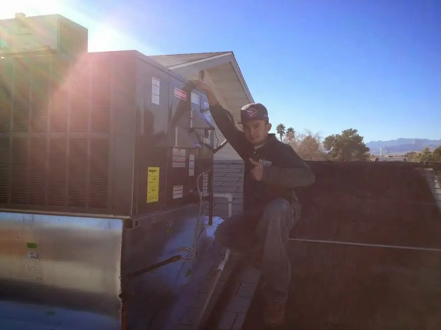 HVAC technician performing AC Tune-Up on a rooftop unit in Whitfield